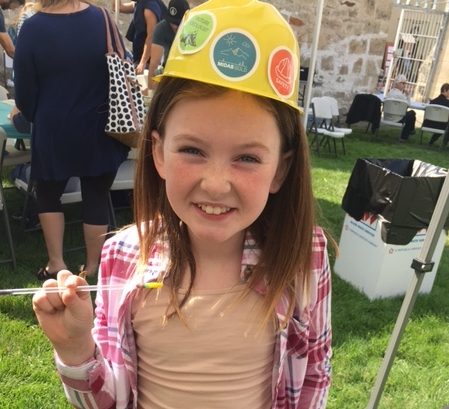 A smiling girl wearing a safety helmet